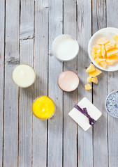 Calendula cream, lip balm, raw bees wax, bath salt soap and other cosmetics on rusty wood table