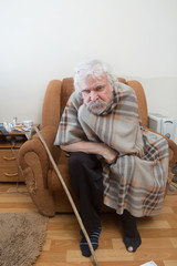 Old sick lonely man in the armchair at home