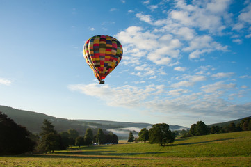 hot air balloon in the sky over misty hills
