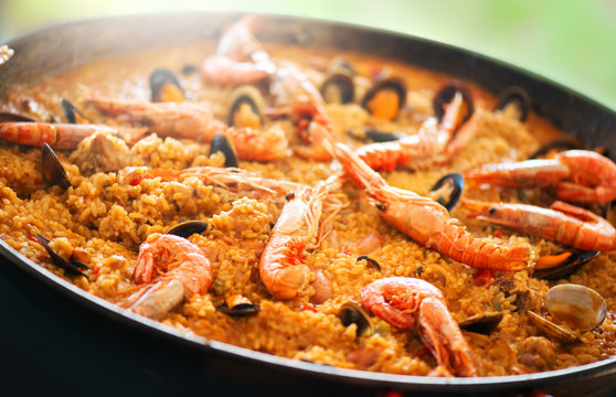Paella. Traditional spanish food, seafood paella in the fry pan with mussels, king prawns, langoustine and squids. Cooking paella outside