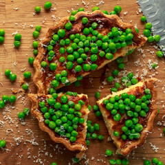 Homemade Cheese and sweet pea quiche, tart on wooden board