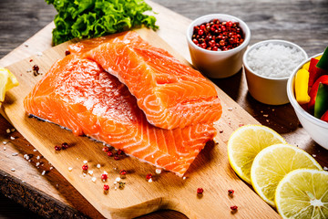 Fresh raw salmon fish served on cutting board on wooden table