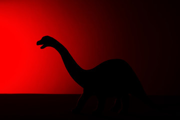 Diplodocus shadow with red light in dark