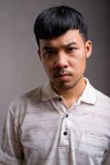 Obraz premium Portrait of young Asian man against gray background