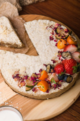 Cake with berries and fruit close-up. White cake on a wooden table.