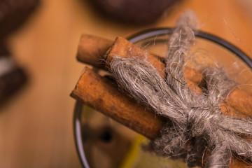 A glass with cinnamon and lemon.