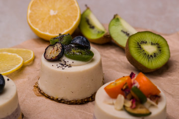 Cake with fruits and berries close-up. White dessert on a wooden table.