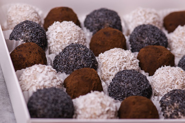 Round candy close-up. Sweets with poppy seeds, coconut, chocolate.