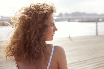 Romantic portrait profile of young Caucasian beautiful lady, admiring sunset on city sky, looking...