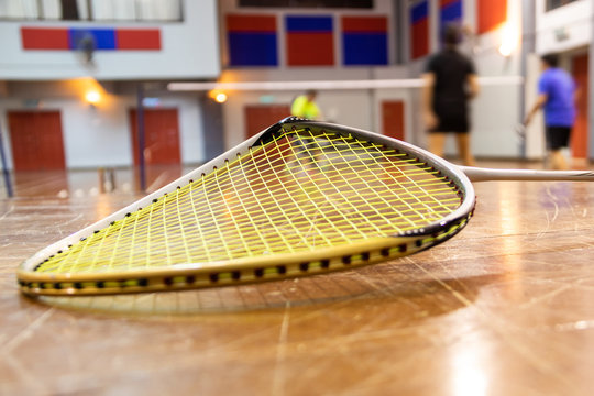 Broken badminton racquet rim with court as background