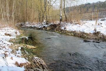 Winter landscape with a river in the foreground