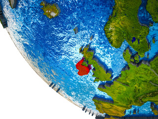 Ireland on model of Earth with country borders and blue oceans with waves.