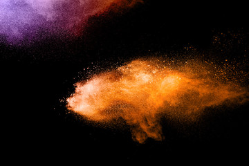 orange dust particles explosion on white background. Powder dust splash.