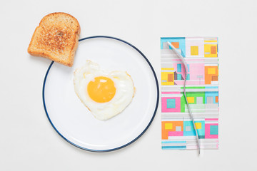Egg fried in a heart-shaped  on a plate with toast