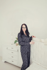 Stylish young woman standing in light apartment
