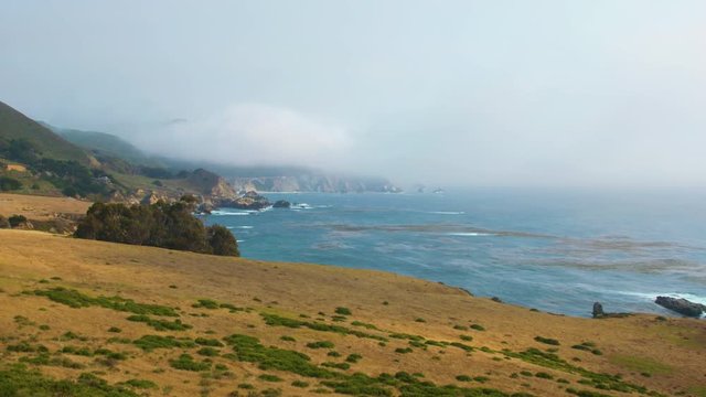Slow zoom in on a distant Bixby Creek Bridge along the coast of Big Sur