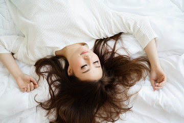 Beautiful Asian girl is sleeping in a clean white bed without dust mites. Deep sleep makes the body fully rest. Repair parts like the brain to make the skin better. Control your heart rate to normal.