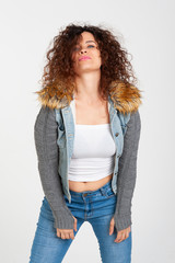 Body positive concept. Smiling curly girl plus size, dressed in casual style, posing at ease in the studio for white background. Emotions.
