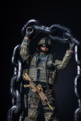 Toy action-figure soldier holding a chain over his head in a show of strength