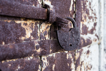 Old rusty padlock hanging on the door