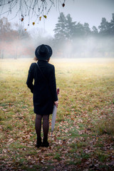 Woman in a black coat in foggy weather