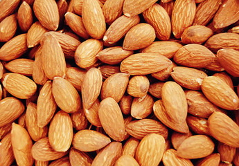 A lot of roasted almond nuts background. 