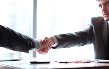 close up.a confident handshake of business partners at the desktop