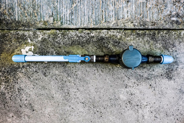 Top view of water meter on concrete background, Open cover of water meter to check counter number of water consumption, water meter with waterspout for home
