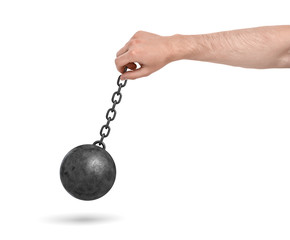 A male hand on a white background holding a black metal chain with a wrecking ball swinging on it.