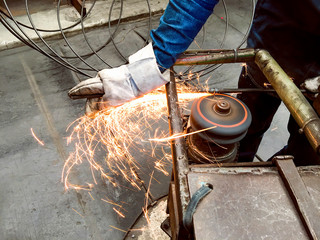 Worker in factory, Welding and Grinding Steel wire, Flash of fire from grinding stone, Metal industry, Operator working in the site, Workplace,  steel structures manufacture workshop