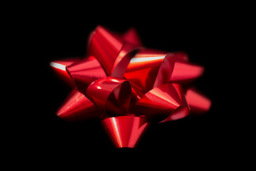 Red satin bow on black background side view