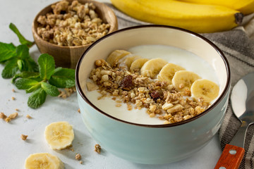 Granola close-up. Granola with yogurt, chocolate and banana on a white stone table. The concept of healthy nutrition and diet.