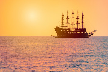 Fototapeta na wymiar Cruise sailboat at sea at sunset on horizon