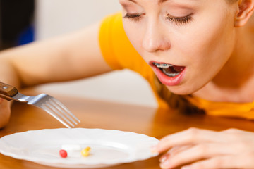 Obraz na płótnie Canvas Shocked woman having pills on plate