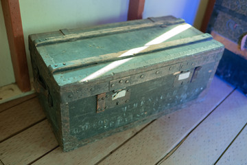 Green military style old wooden chest on the floor.
