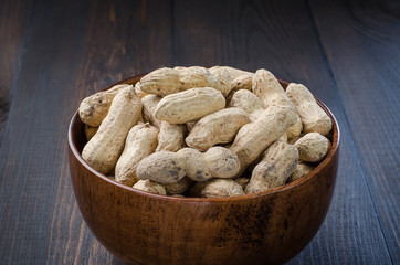 Peanuts in the peel on a dark background.