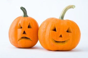 Two cut pumpkins with halloween faces isolated on white background