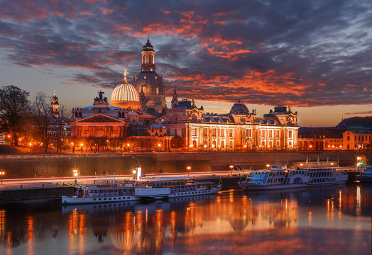 Colorful sunset with colorful dramatic sky, over the famouse Old Town architecture in Dresden reflected in water. Scenic sunset view of ancient buildings in Dresden, Bavaria, Germany. Creative image