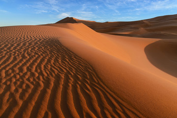 Fototapeta na wymiar The dunes of Erg Chebbi in Morocco. Ergs are large seas of dunes formed by wind-blown sand