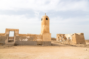 Ruined ancient old Arab pearling and fishing town Al Jumail, Qatar. The desert at coast of Persian Gulf. Abandoned mosque with minaret.