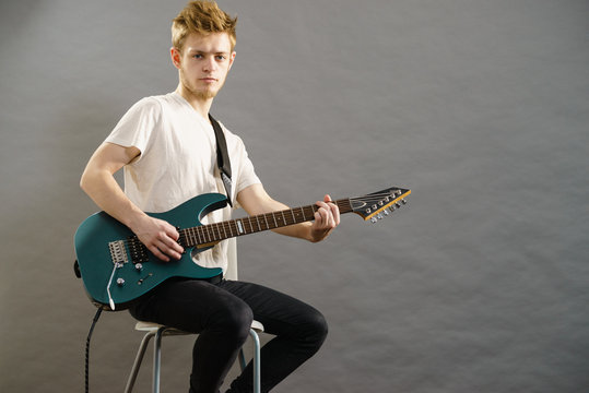 Young man playing electric guitar