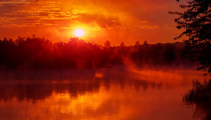 heerlijke mistige ochtend. majestueuze rode zonsopgang boven het mistige meer