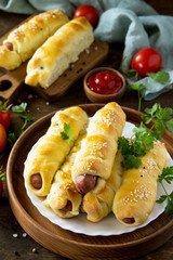 Sausage in Dough in rustic style on wooden table.