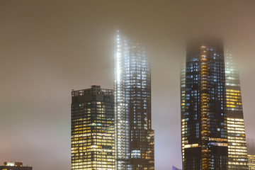 Manhattan skyline during rain, clouds sky.    