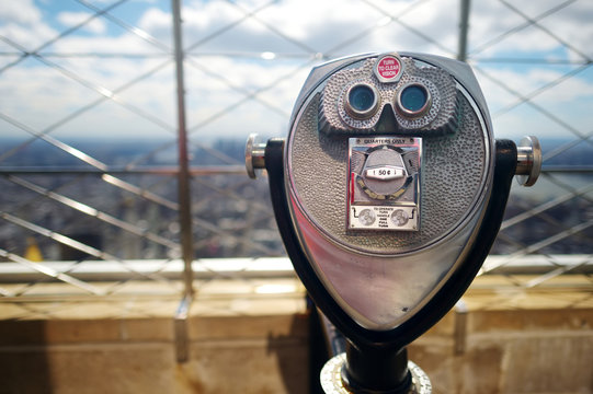 Tourist coin operated binoculars at the top of the Empire State Building in New York City - Powered by Adobe