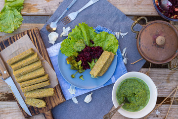 Vegan, vegetarian lunch, dinner with raw flax sunflower seeds bread slices, avocado spinach dip sauce, fresh beetroot garlic salad and steamed, cooked broccoli in pot. Healthy food, paleo diet