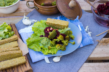 Vegan, vegetarian lunch, dinner with raw flax sunflower seeds bread slices, avocado spinach dip sauce, fresh beetroot garlic salad and steamed, cooked broccoli in pot. Healthy food, paleo diet