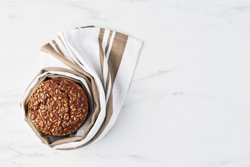 Whole wheat bread on white marble table. Top view, copy space.