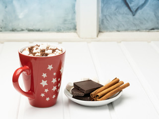 Hot cocoa on the background of a frozen window