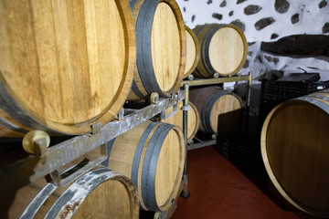 Close-up of Many Wooden Barrels in oak Stored At Wine Cellar
